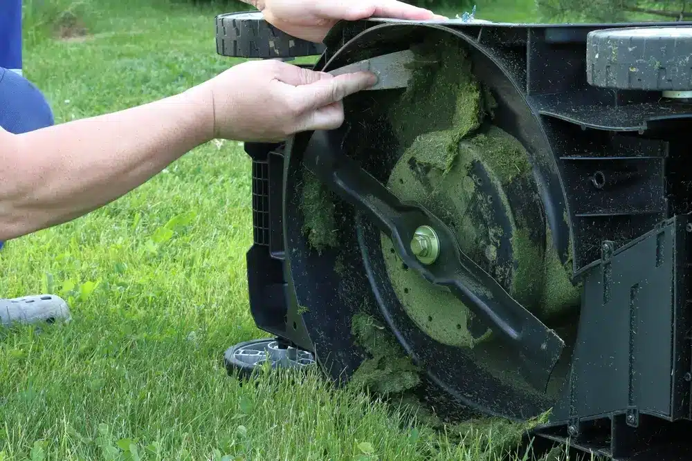 Scraping grass clippings from the lawnmower